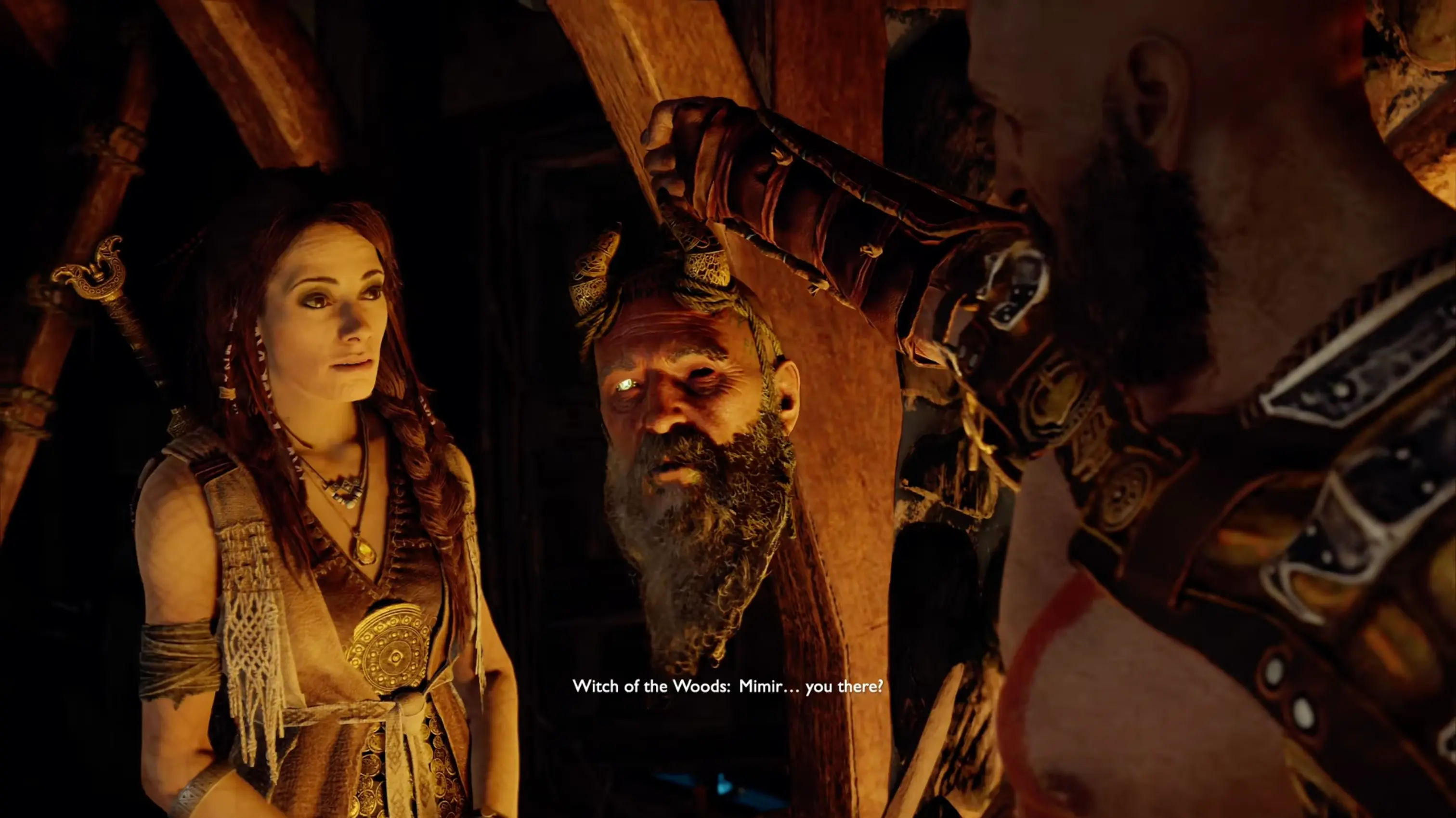 The reanimated, glowing-eyed severed head of Mimir hanging from Kratos's belt, acting as the game's brilliant lore-giver and comic relief.