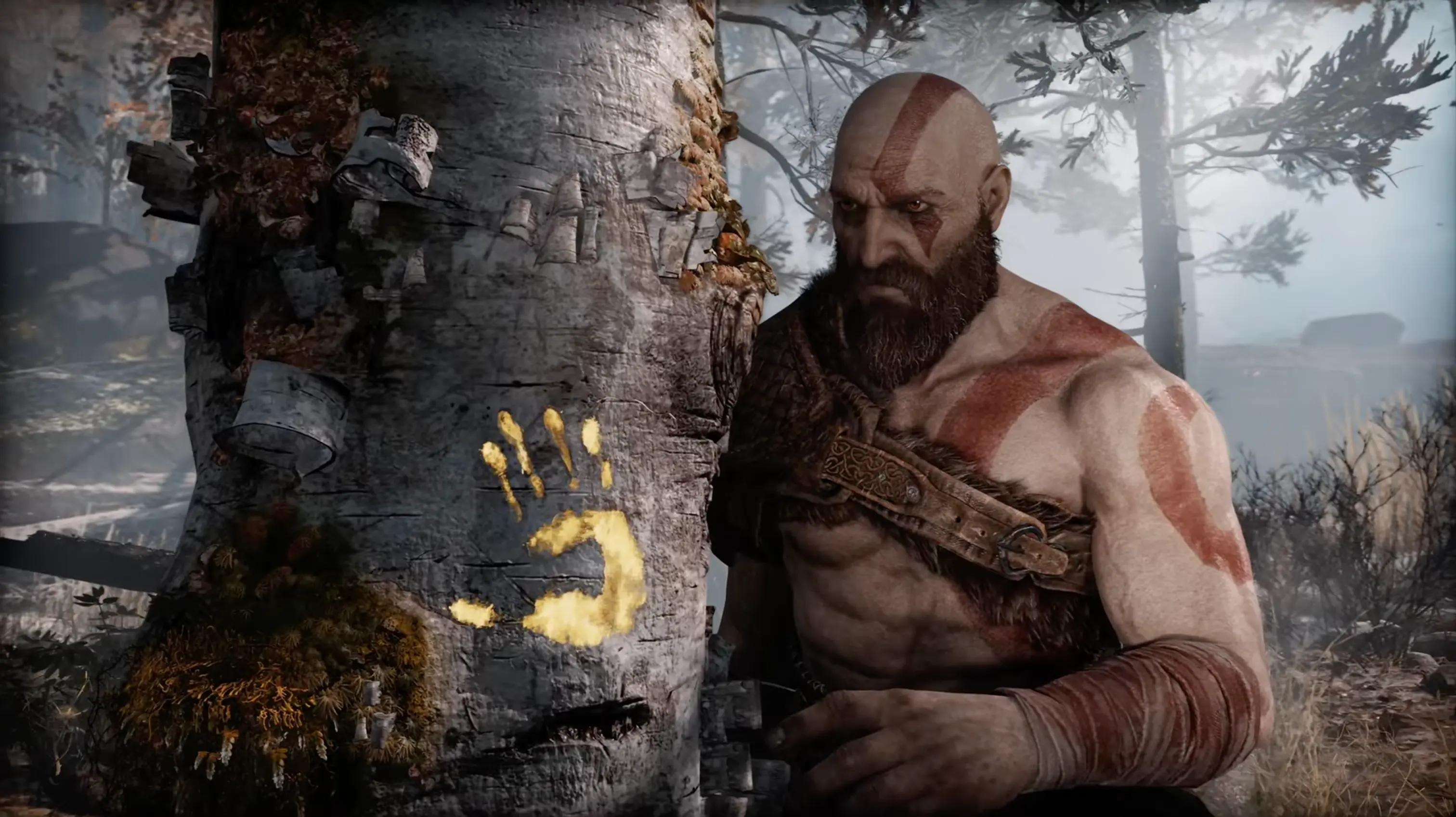 A somber Kratos holding his Leviathan Axe, standing before a birch tree marked with a golden handprint in the snowy Midgard forest.
