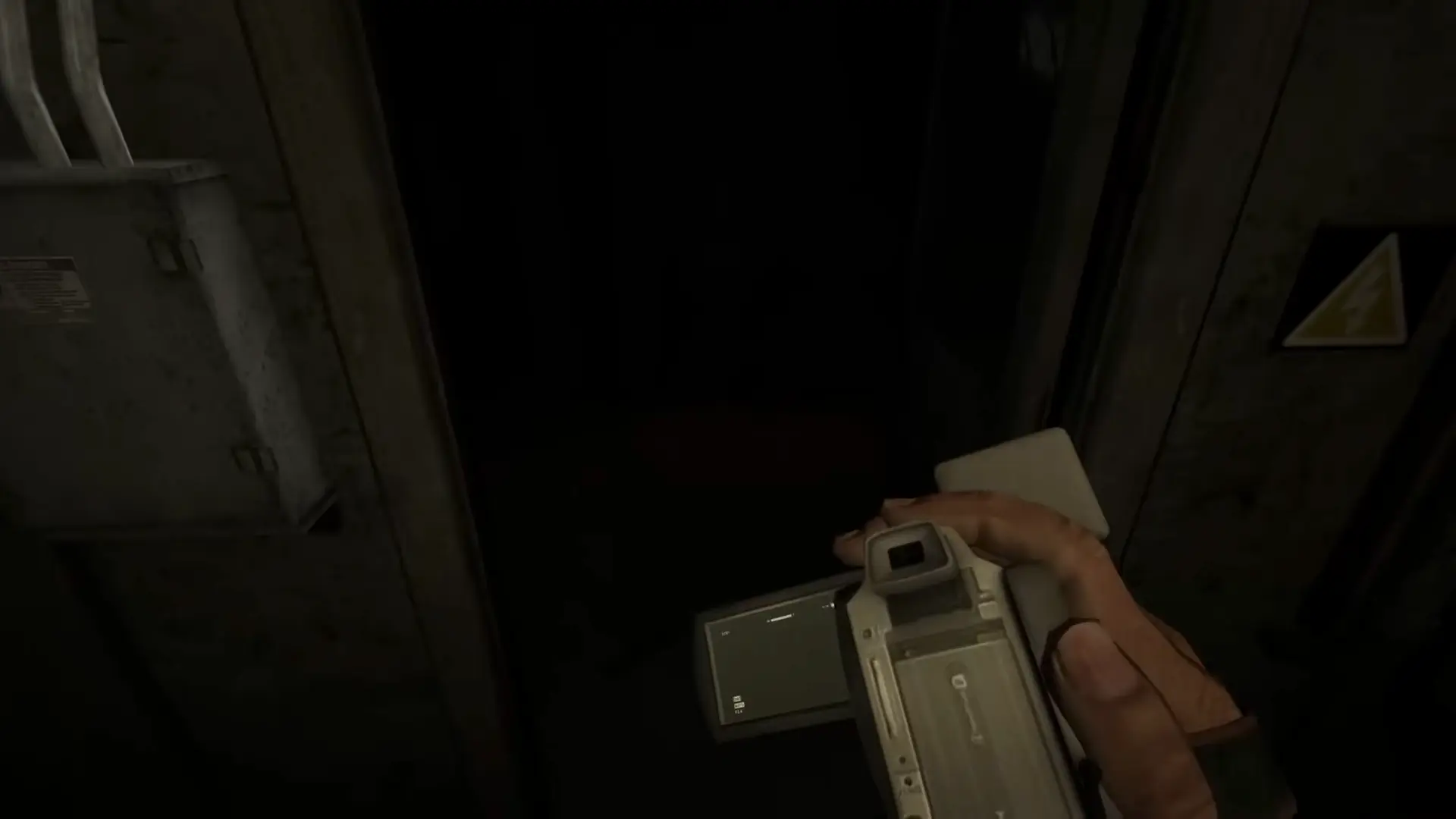 Miles desperately fumbling to load a fresh pair of AA batteries into his camcorder while standing in a completely dark ward.