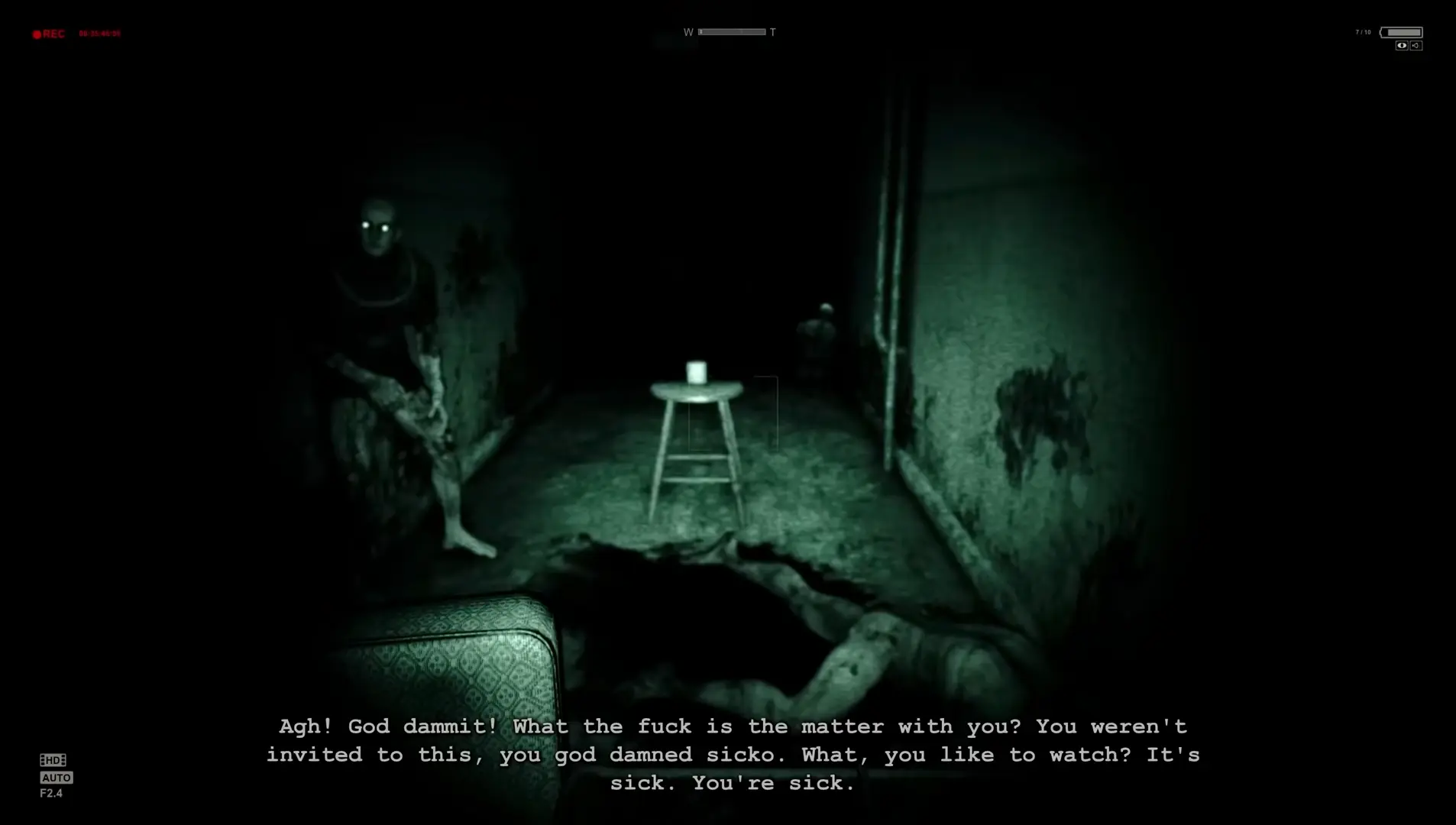 The iconic, grainy green night vision view from the camcorder, showing a blood-smeared hallway in the pitch dark.