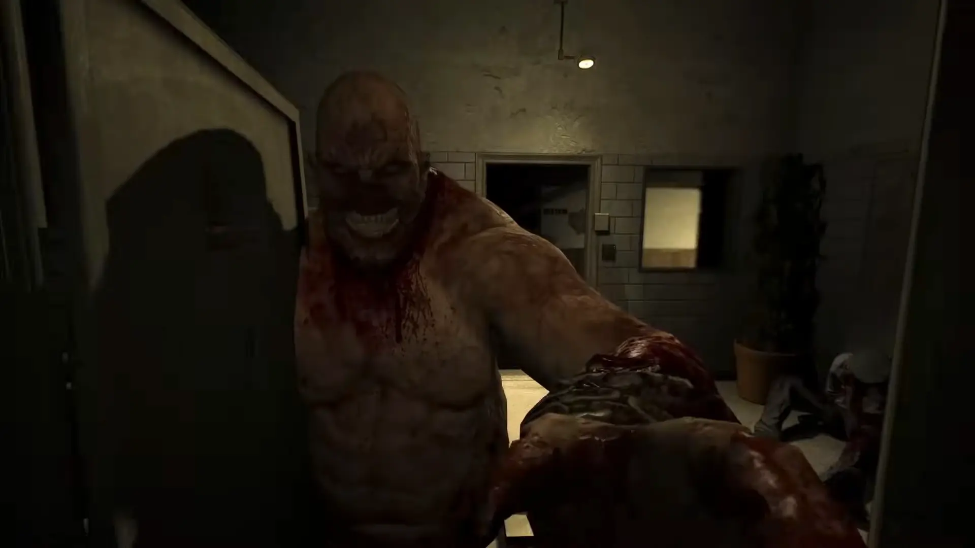 The massive, terrifying figure of Chris Walker tearing a heavy metal door off its hinges as he hunts the player.