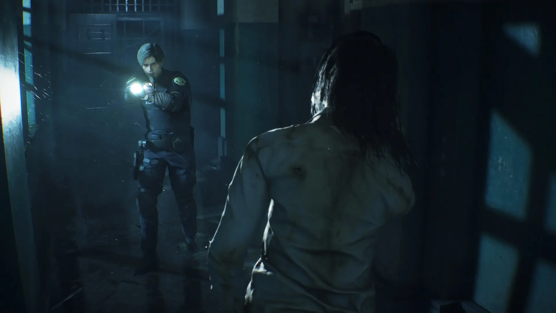 A close-up of a zombie lunging in a dark hallway, showcasing the game's horrific, detailed gore and damage modeling.