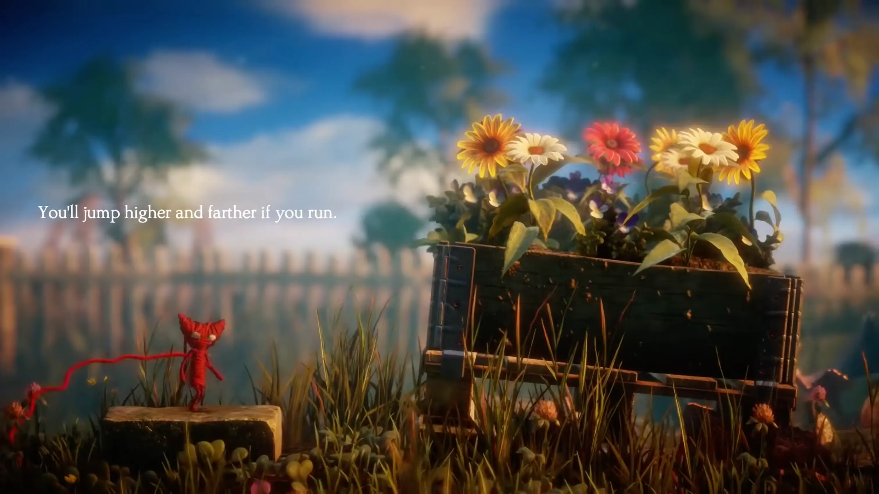 Yarny exploring a lush, oversized garden environment with giant sunflowers and grass blades.
