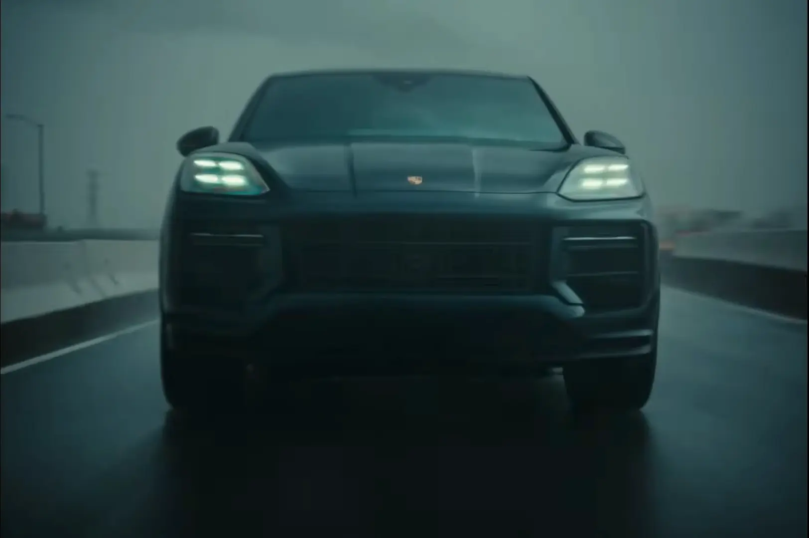 A close-up of the Porsche's front grill, modified with heavy steel ramming bars and auxiliary rally lights cutting through the fog.